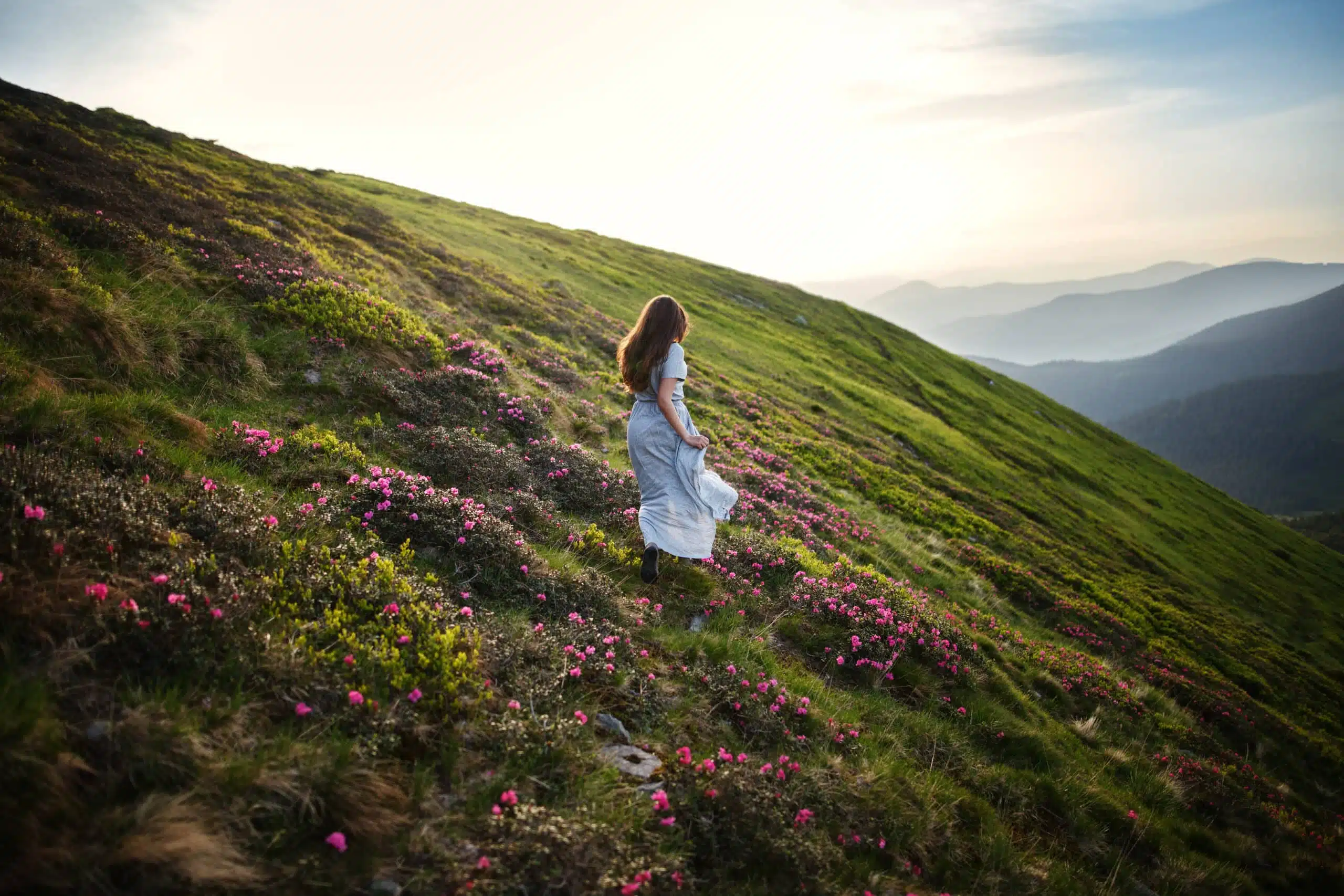 Beautiful woman in dress running in the mountains.