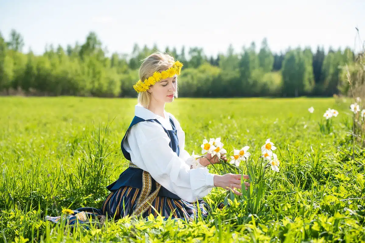 Young woman in a dress in a field with daffodils.