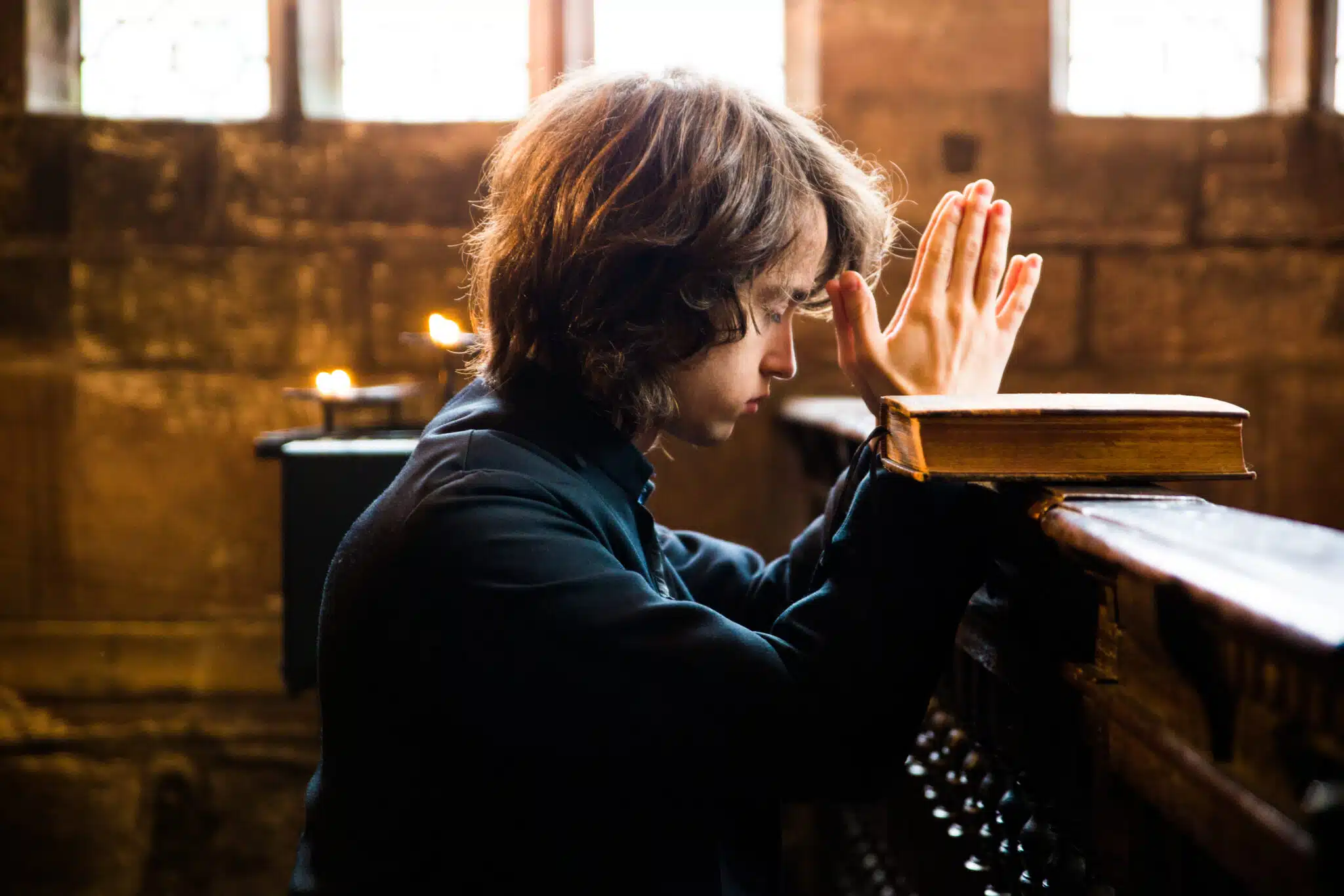 Young boy praying in a church