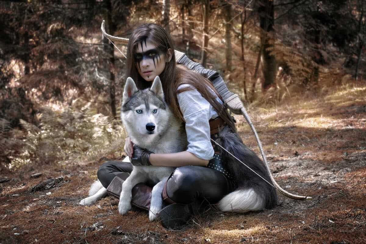 Fairytale art photo of a hunter with a wolf and a bow