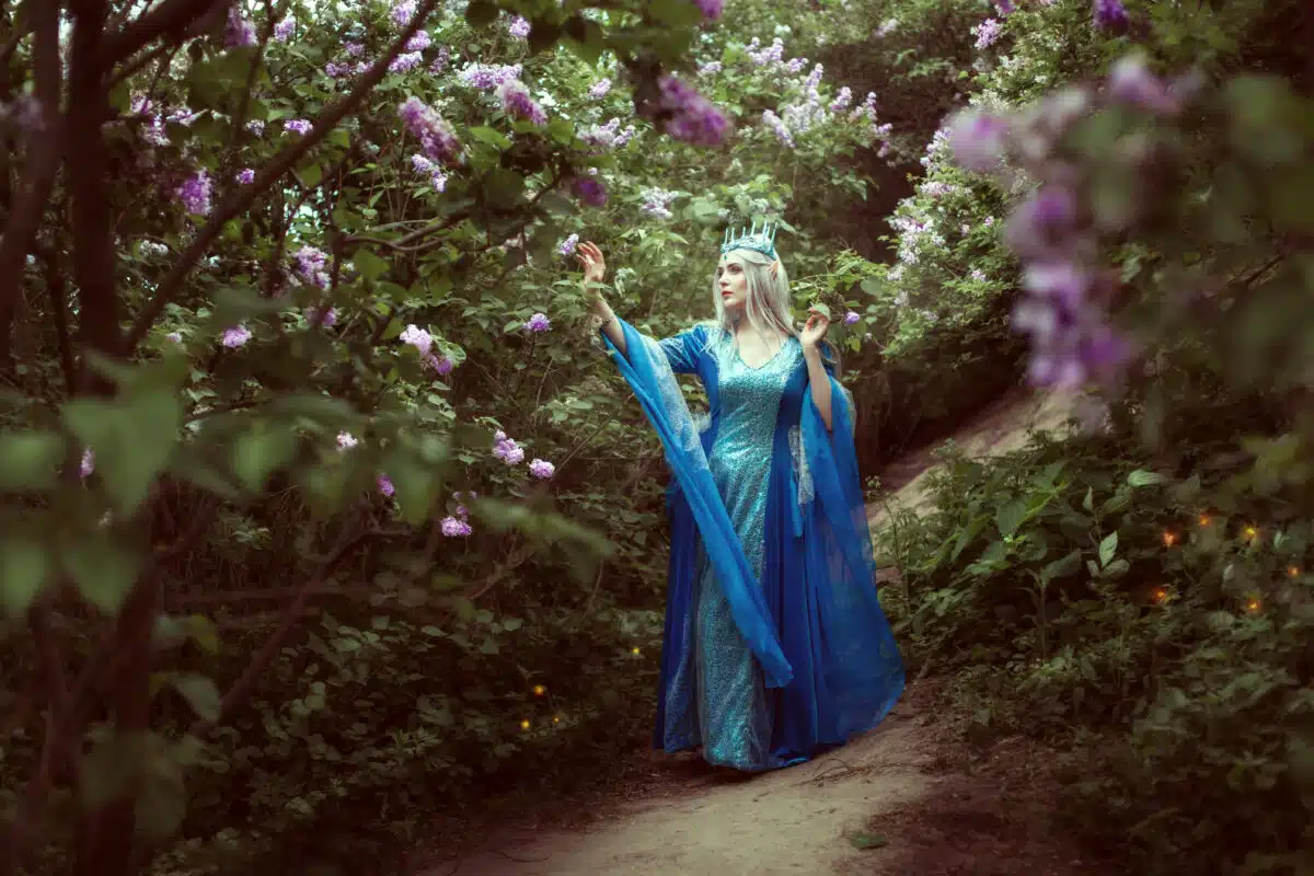 Young elf woman walks in a fairy forest.