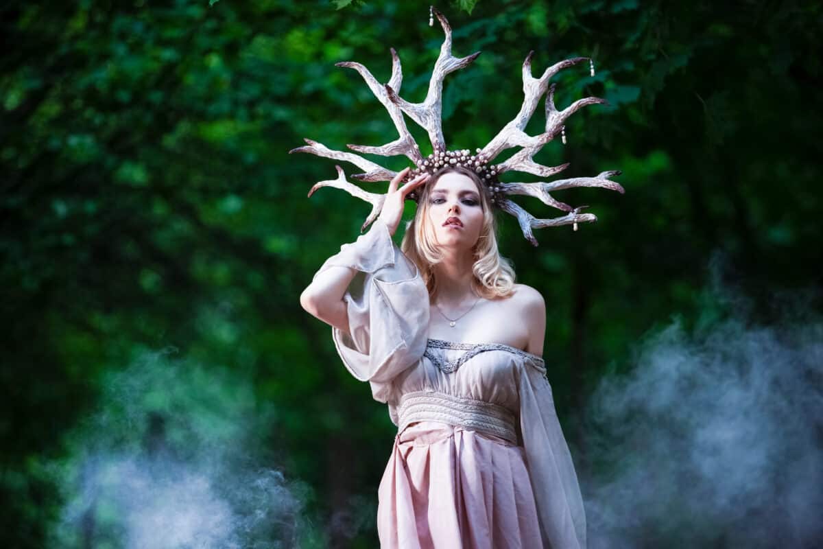 fantasy woman with deer antlers wearing a beautiful pink off shoulder dress