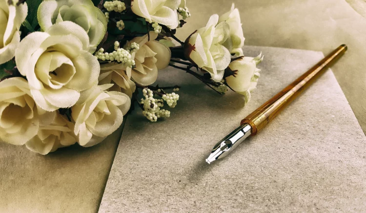vintage pen, white roses, and old paper