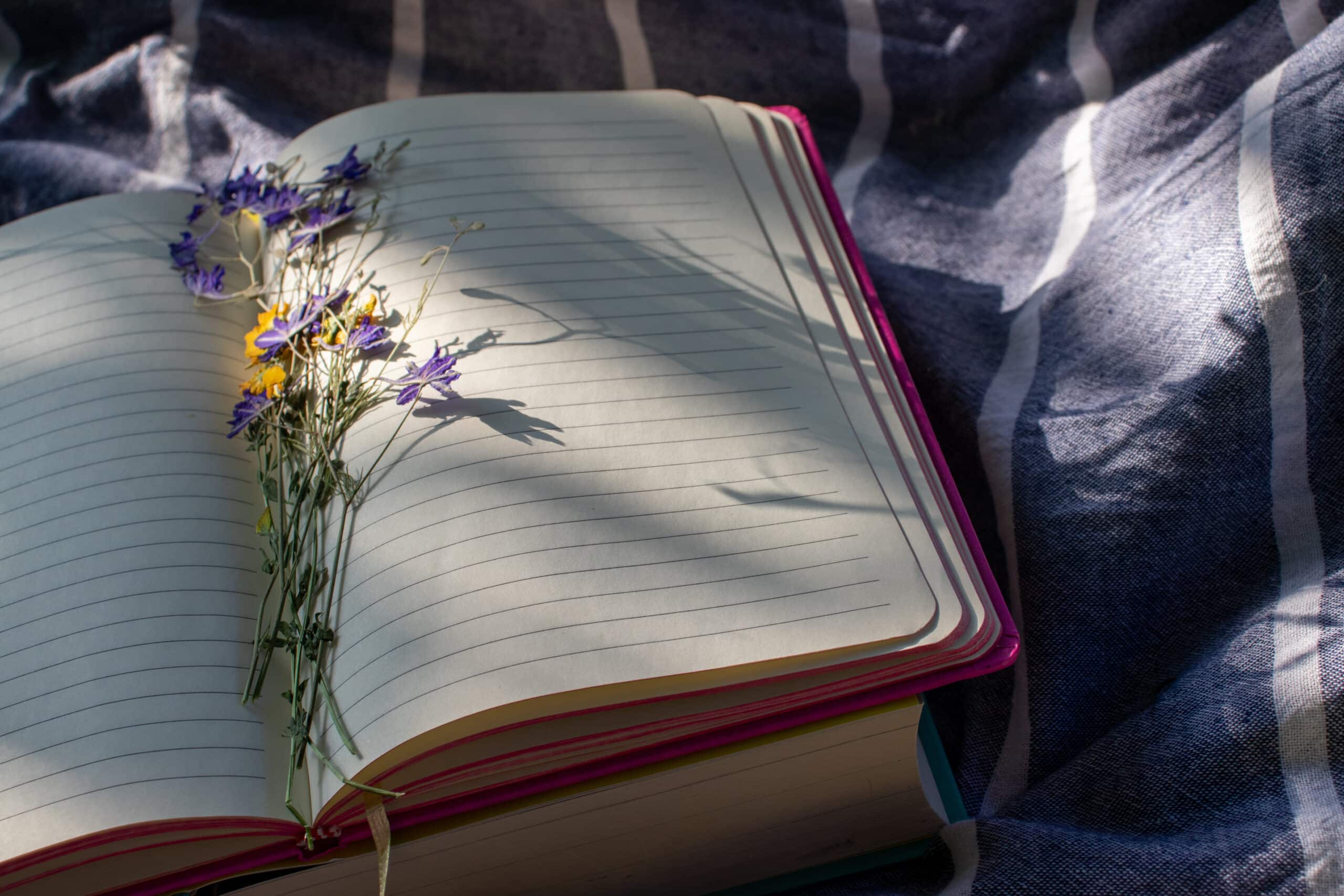 an open notebook with flowers on fabric background